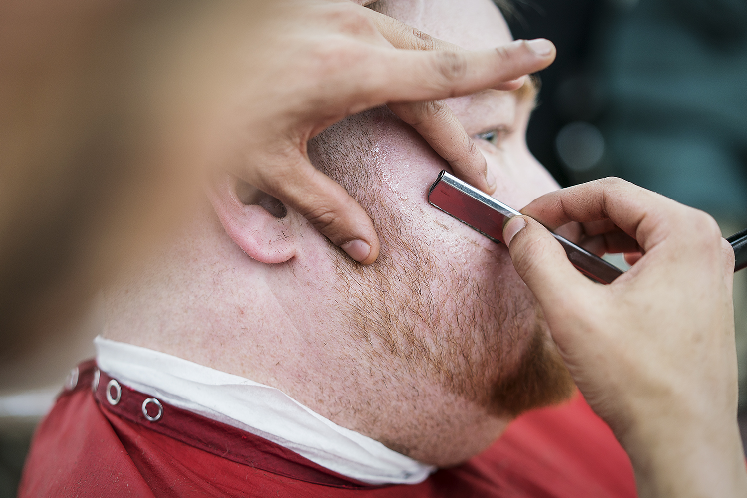 Flint, MI - Tuesday, February 6, 2018: Manuel Rodarte, 35, from Saginaw, a student at the Flint Institute of Barbering., has his beard lined up with a straight razor by barber Nick Gallardo, 26, from Bay City, during the slow hours of the day when st