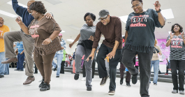 Gardell Haralson, 64, of Flint (center right) takes a break from emceeing to dance with the Hustlers at the Hasselbring Senior Community Center. "It gave me the feeling I was doing something," he said about the progress of the Hustlers. "They're not 