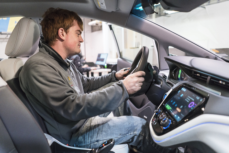 Flint, MI - Friday, November 10, 2017: Graduate student and student coordinator for the SAE/GM AutoDrive Competition, Alex Rath, 22, sits in the driver&#39;s seat of the new Chevrolet Bolt and surveys the driver information center as it is connected to a
