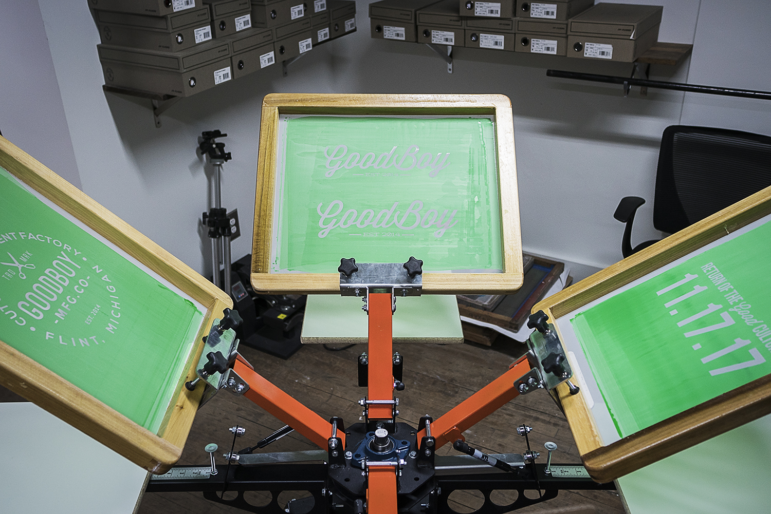 A four station screen printing press waits at the ready in the production area of the new GoodBoy Clothing storefront in downtown Flint.