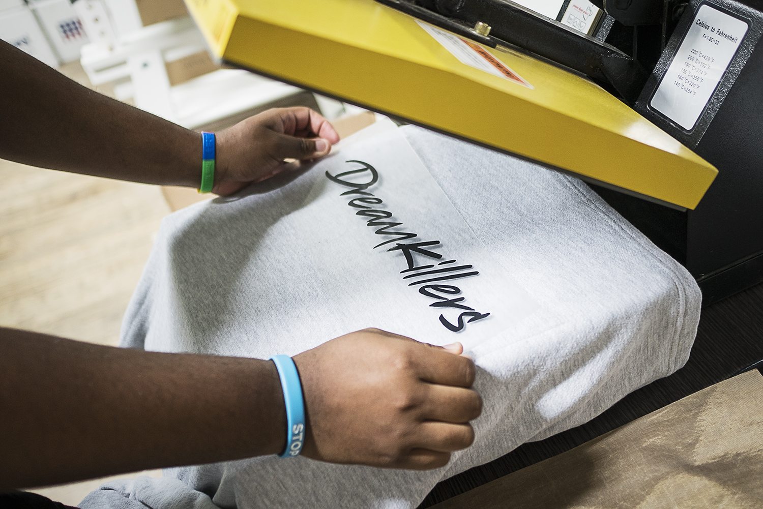 In the production area of the new GoodBoy Clothing storefront in downtown Flint, production manager Andre McGee, 23, of Flint runs application tests of vinyl lettering onto clothing garments in preparation for the grand opening event on Friday, Novem