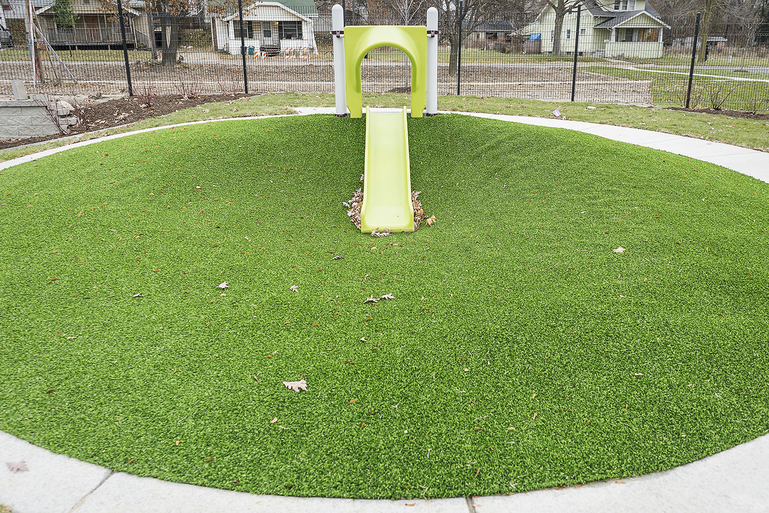 Flint, MI - Tuesday, November 21, 2017: A small slide drops down into a lush field of green grass outside of the new Educare Center in Flint.