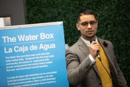 Asa Zucarro, executive director of the Latinx Technology and Community Center on Lewis Street, speaks to a crowd at a public showing of The Water Box on Monday, December 2.