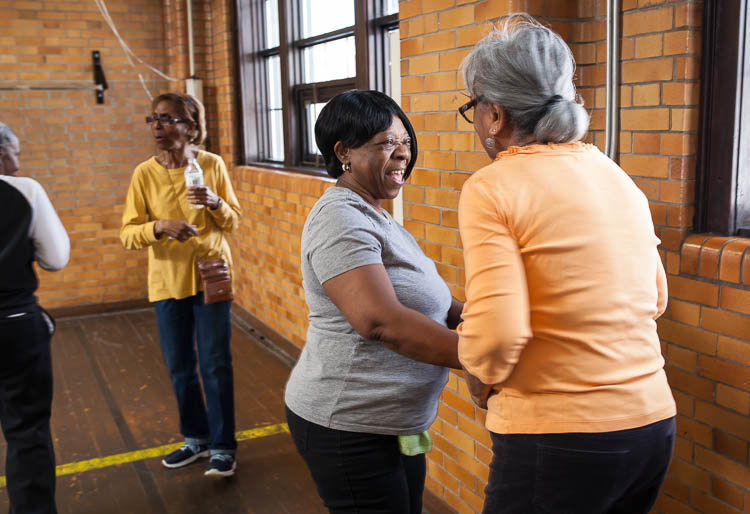 Phyllis Abrams of Flint (center) spends a moment socializing with Carolyn Jackson of Flint during a break in their line dancing class in the small gym at Berston Field House in Flint.