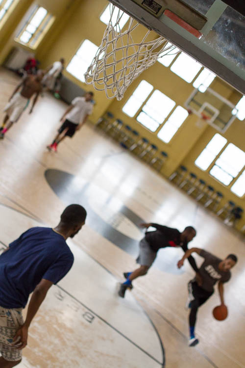 Young men, mostly in their 20s, play basketball at Berston Field House in Flint.