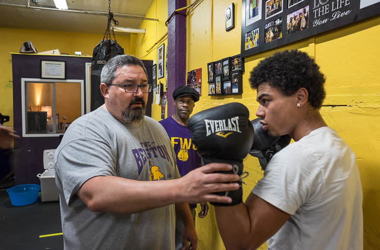 Berston boxing coach Steve Ayala of Ortonville works with Seth Woodbury, 18, of Swartz Creek, on his form in the boxing gym at Berston. Woodbury has been training at Berston for just a few weeks. Coach Paul LeSears looks on in background.