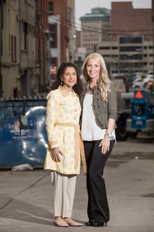 Kathleen Gazall (left) and Kristy Bearse, both members of the Friends of the Alley Committee, pose in Brush Alley—at the heart of new downtown investment. A 30-day, $50,000 fundraising campaign to string lights in the alley kicks off on Monday, April