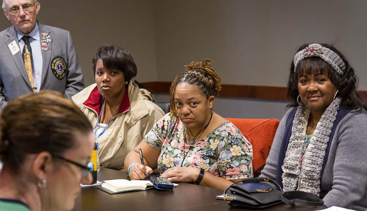 Carma Lewis (center) takes notes during a meeting of Recovery Resource Group. 