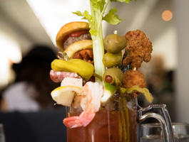 The Loaded Bloody Mary includes cheeseburger slider on a homemade brioche roll, bacon, sweet potato waffle fries, shrimp, roasted jalapeno, asparagus, chicken nuggets, pickle and olives—all atop Cork's homemade mix.