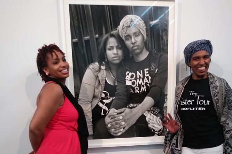 Shea Cobb and Amber Hasan stand next to their portrait on display at Gavin Brown’s Enterprise in New York.