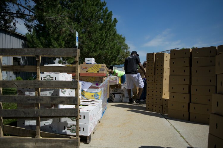 Boxes and pallets line the sidewalk of the Hasselbring Senior Center parking lot.  