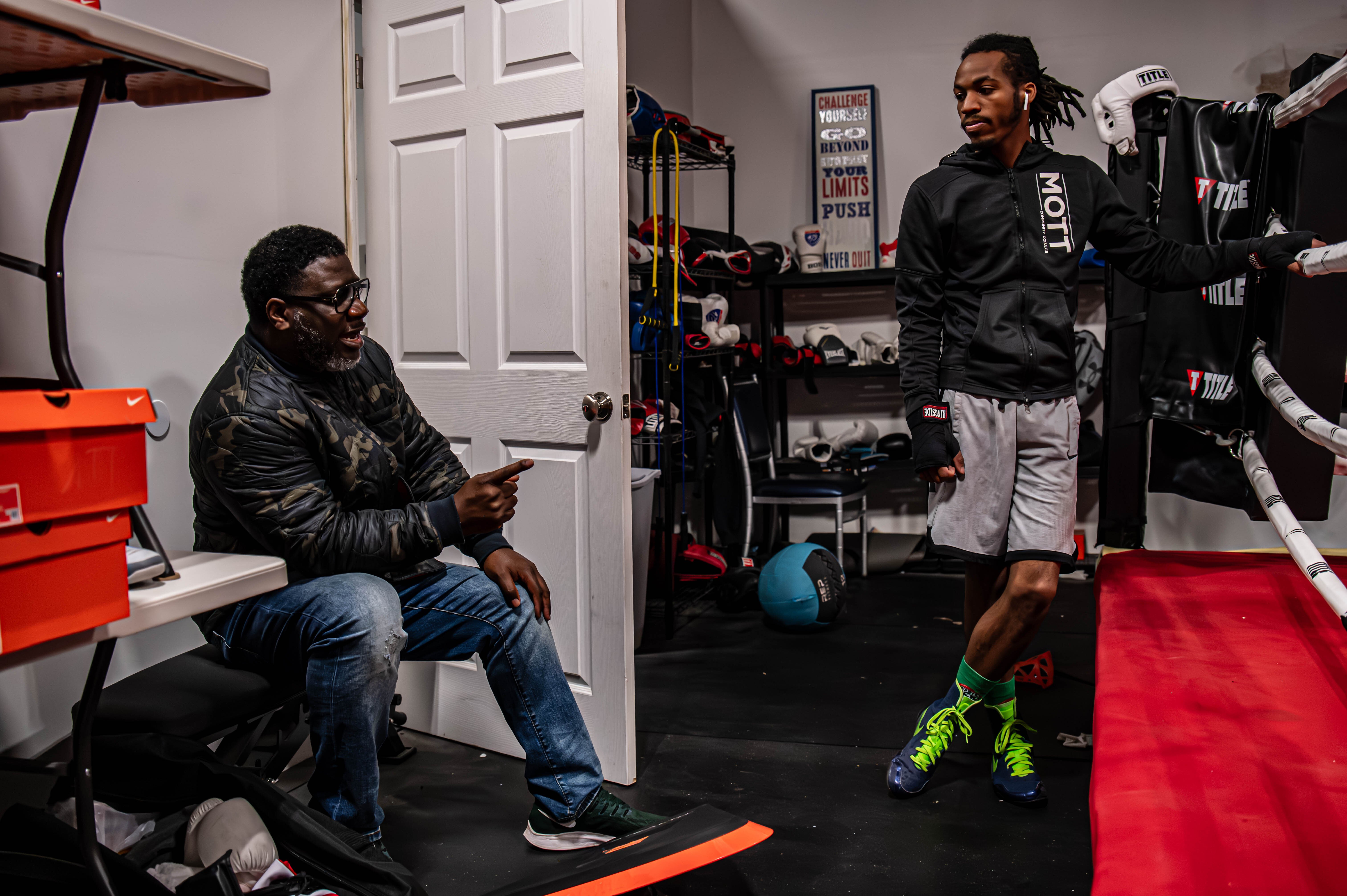Jaylyn Nichols (right) discusses workouts for the week with boxing coach Andrew Aikins (left).