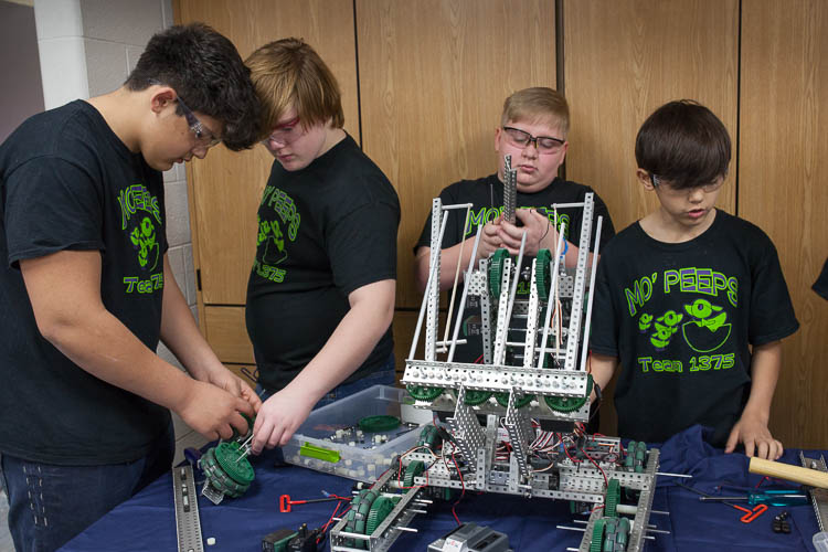 (From left) Sonny Fragoso, 14, of Carman-Ainsworth Middle School; Austin Cook, 14, of Swartz Creek Middle School; Max Johnson, 11, of Rankin Elementary; and Adrien Fragoso, 12 of Carman-Ainsworth Middle School build a robot. The students are members 