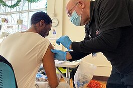 A man receive COVID vaccination at DRM clinic in Grand Rapids.