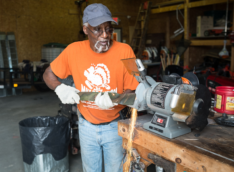 Hurb Pitts sharpens a lawn mower blade at the Community Tool Shed, located on King Avenue in Flint. 