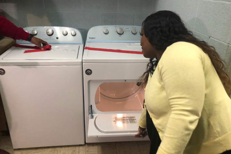 Chia Morgan, treasurer for Well of Hope, shows off the new dryer donated to Durant-Tuuri-Mott.