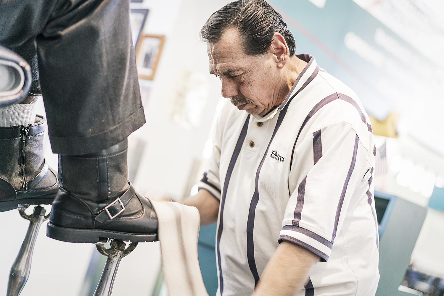 Flint, MI - Friday, January 26, 2018: Joe Garza, 69, of Mt. Morris shines a customer's shoes at the shoe shine stand at Bishop International Airport.