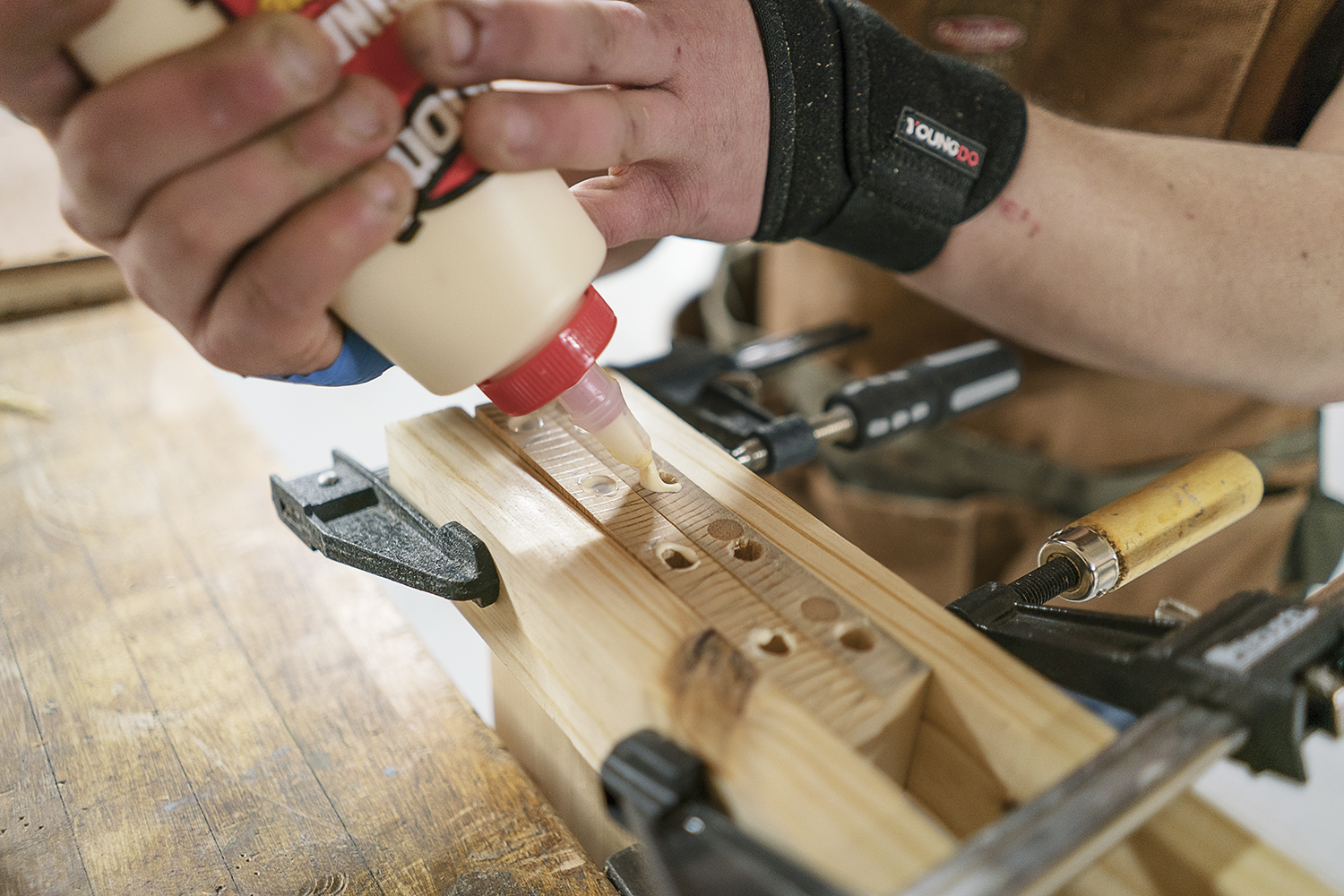 Flint, MI - Friday, February 2, 2018: Flint resident Michael Callahan squeezes glue into holes drilled for dowel rods before assembling his cabinet at Factory Two in Flint.