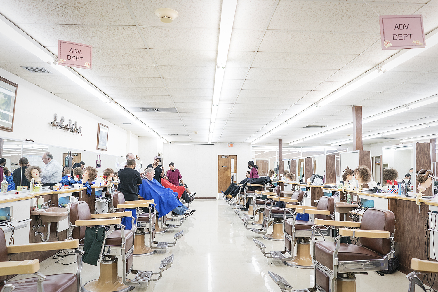 Flint, MI - Tuesday, February 6, 2018: Just after lunch on a slow Tuesday, students cut the hair of other students and other walk-in customers at the Flint Institute of Barbering.