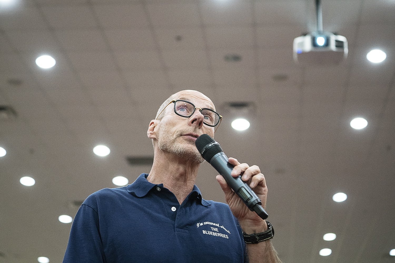 Flint, MI - Friday, May 4, 2018: Blueberry Founder and Fenton Twp. resident Phil Shaltz, 69, looks at portrait of his granddaughter projected onto the screen as he talks about why he is "concerned about the blueberries" during the 5th Annual Blueberr