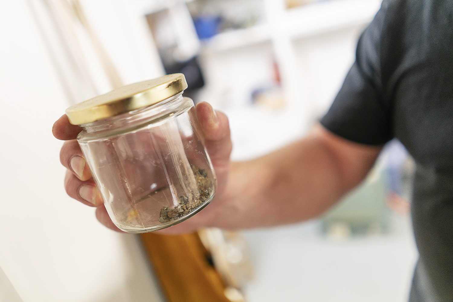 Flint, MI - Tuesday, May 8, 2018: Flint resident and metalsmith Robert McAdow holds a jar containing small pieces of gold he panned out of a creek in California during his childhood.