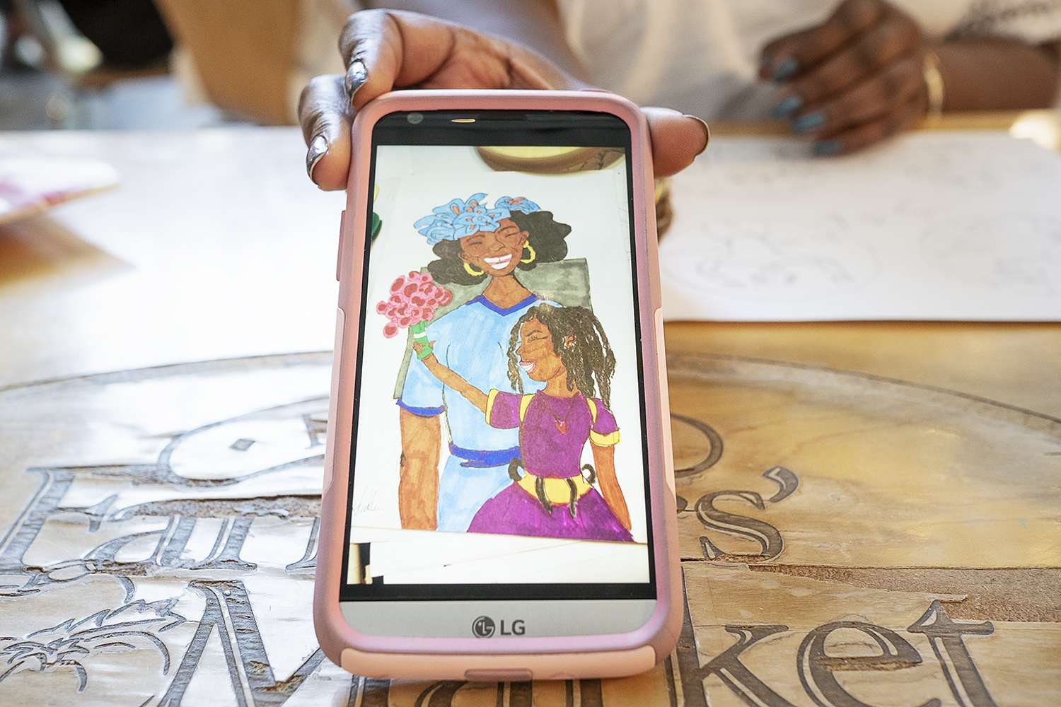 Flint, MI - Thursday, June 7, 2018: Bookmarks, postcards and buttons created by Loving Me Inc. sit on a table at the Flint Farmers' Market downtown.