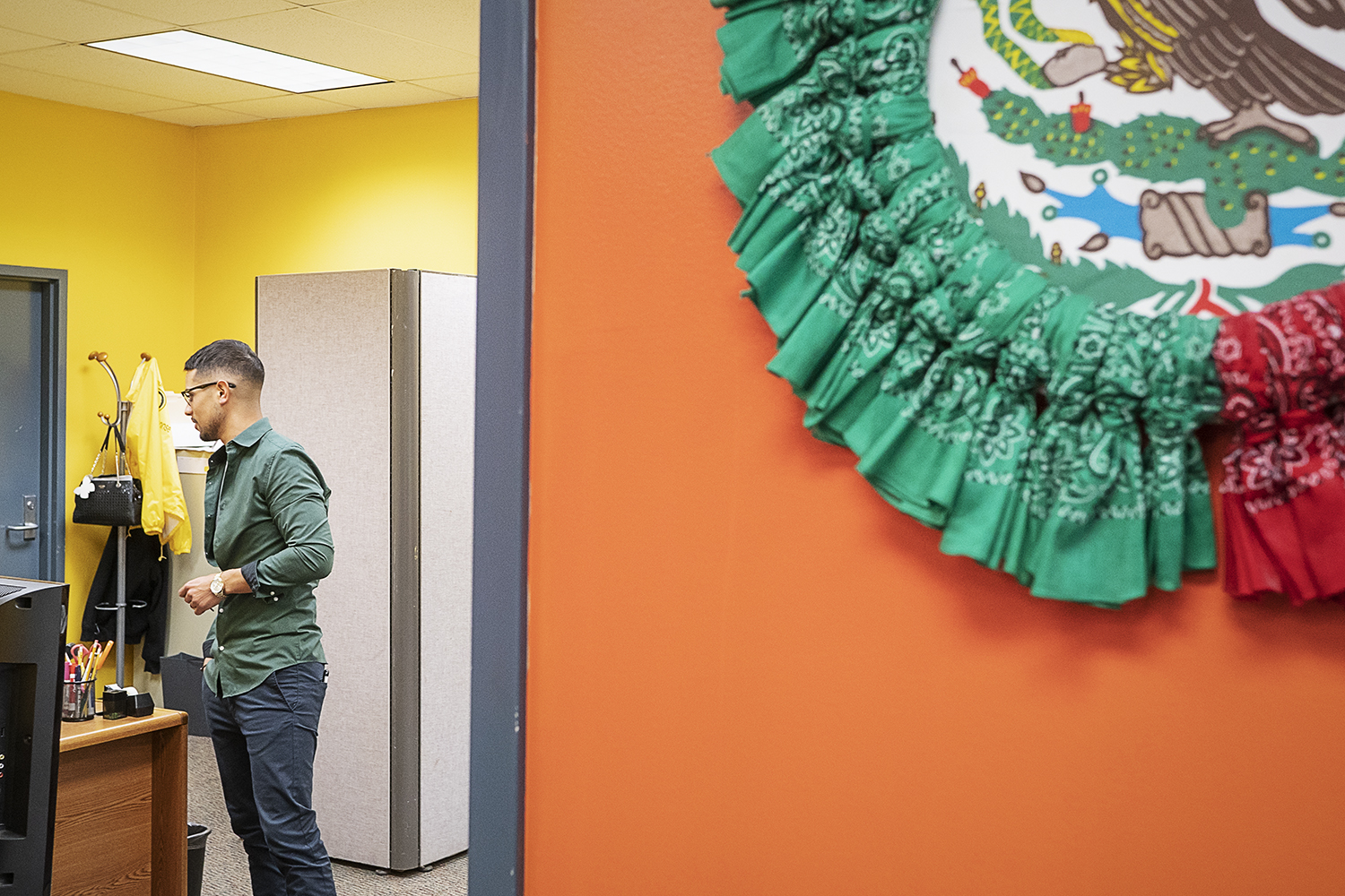 Flint, MI - Tuesday, June 19, 2018: Asa Zuccaro (26) from Burton, the director of the Hispanic Technology and Community Center of Flint, speaks with a staff member at the Hispanic Technology and Community Center of Flint.