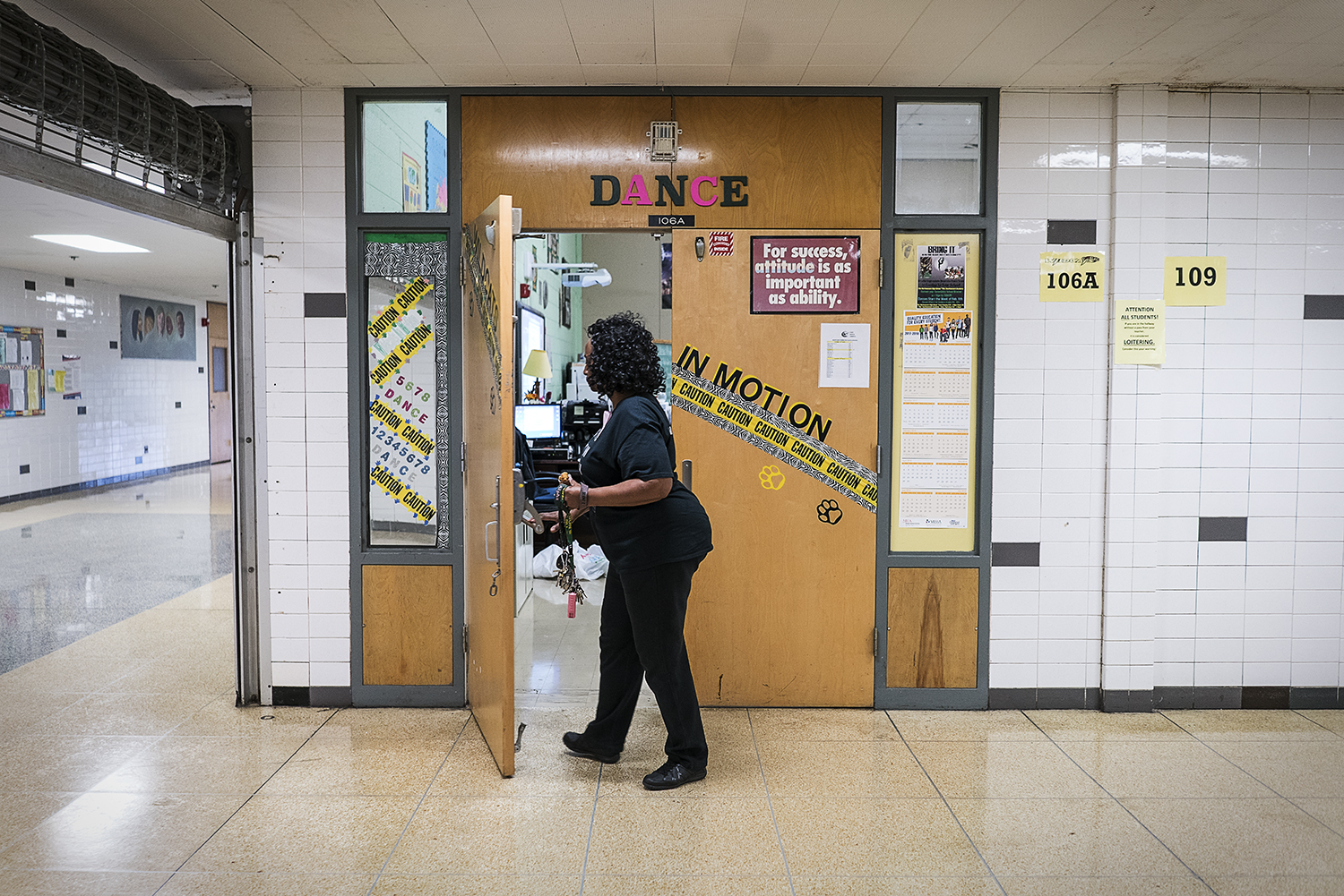 Sheila Miller-Graham props open the door to her classroom at Flint Northwestern High School to wheel homecoming decorations back into storage. 