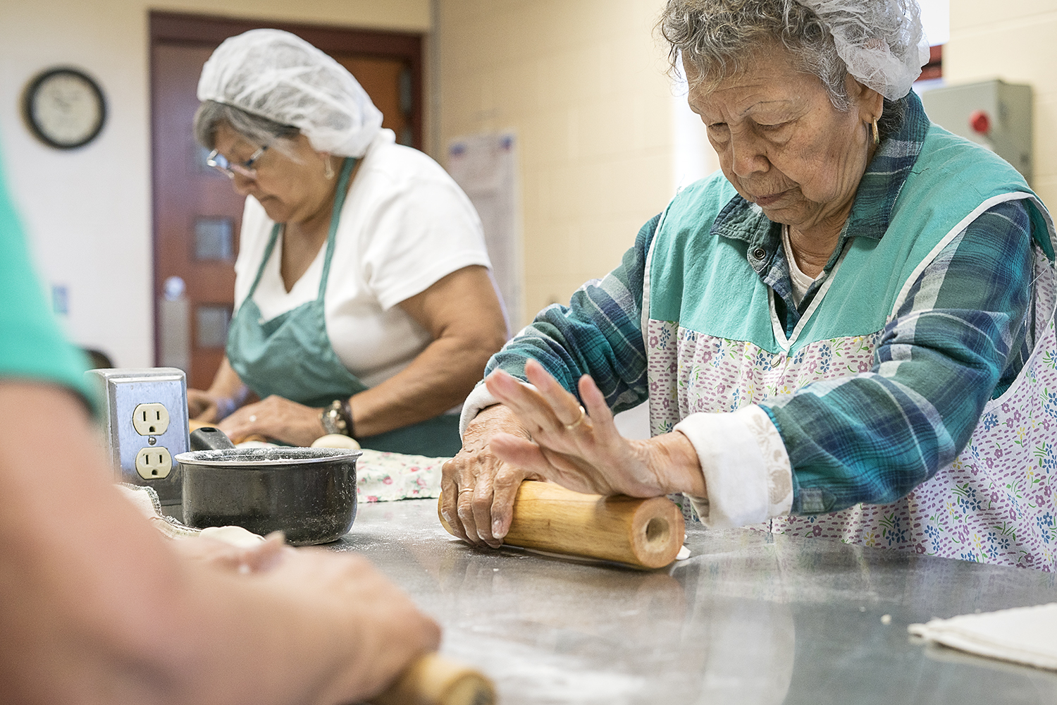 Jane Rubio, 73, of Burton (left) and Lupita Vargas, 87, of Flint, roll out balls of masa before placing them on a tray to head to the cooktop in the San Juan Diego Activity Center kitchen at Our Lady of Guadalupe. 