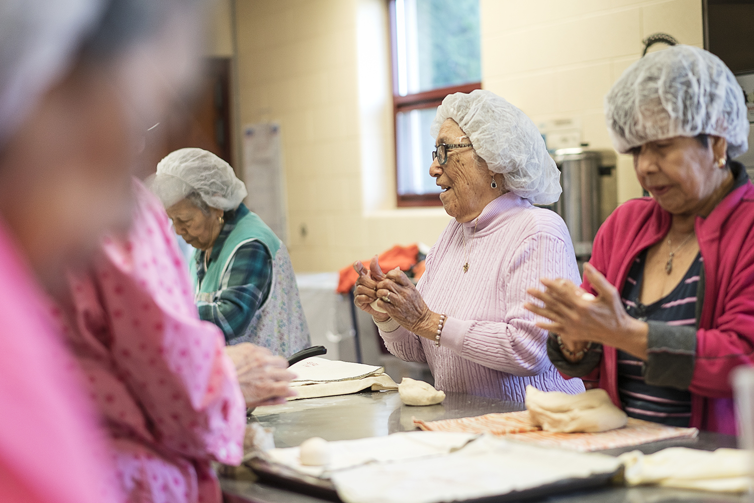 Laughter and conversation are major ingredients of the Tortilla Factory. Linda Quintanilla, 90, of Flushing (center) and Vina Shattuck, 70, from Flint, roll small balls of masa.