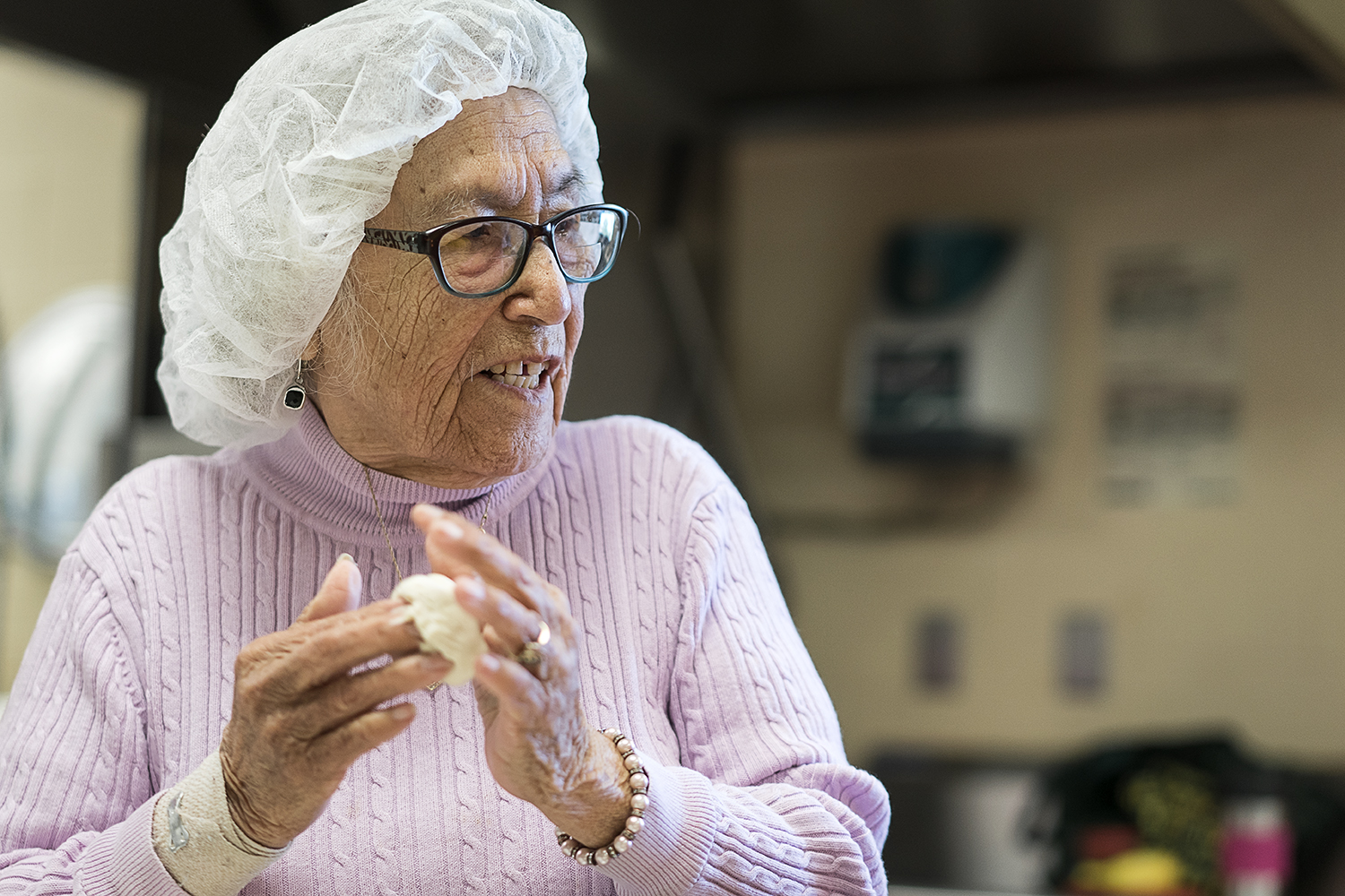 Linda Quintanilla, 90, of Flushing, rolls a small ball of masa between her hands as she chats with the other women making tortillas in the kitchen at the San Juan Diego Activity Center.