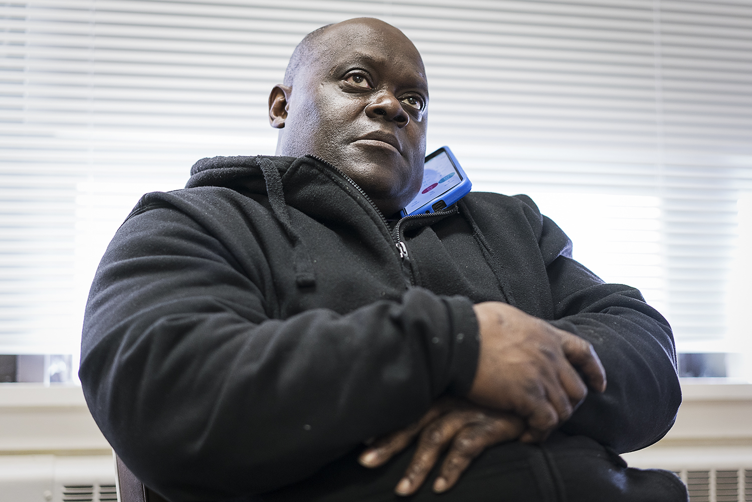 Flint resident Kevin Croom sits behind his desk at Asbury United Methodist Church while on hold with Gordon Food Service. In addition to being the site coordinator for water deliveries, Croom is also the executive chef and neighborhood connection man