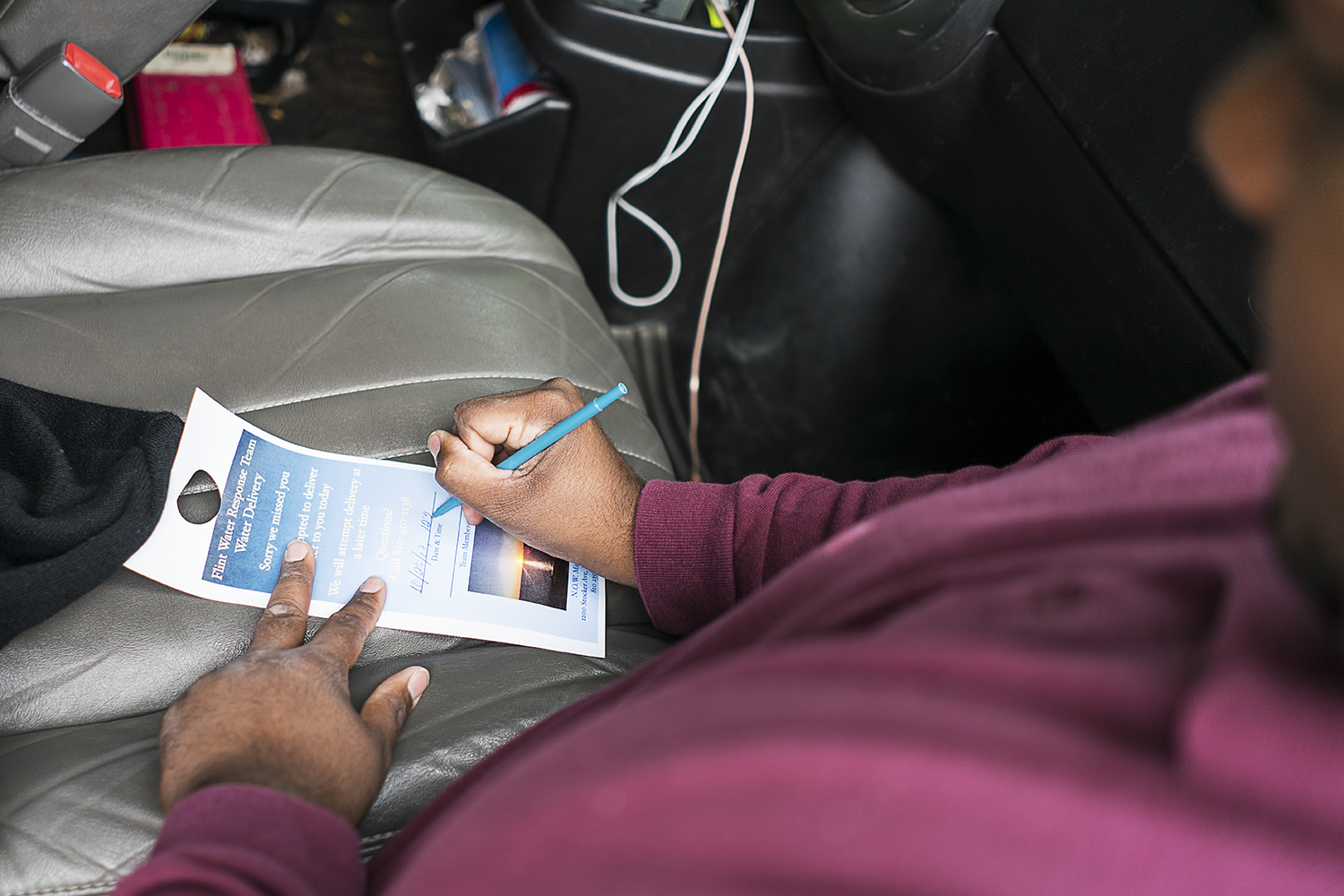 Flint resident William Harris, 31, leaves a note to let residents know that a water delivery was attempted at their home. His team visits between 60 and 70 homes each day. Water delivery is available for residents who cannot making it to the water di