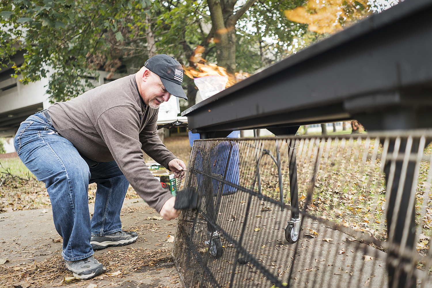 Steven Moore, 52, of Davison cleans the grate of the large grill at the Flint Community Cookout at the Riverbank Park. Moore, a retired police officer, enjoys being able to connect with the community in a positive way, which wasn't always the case wh