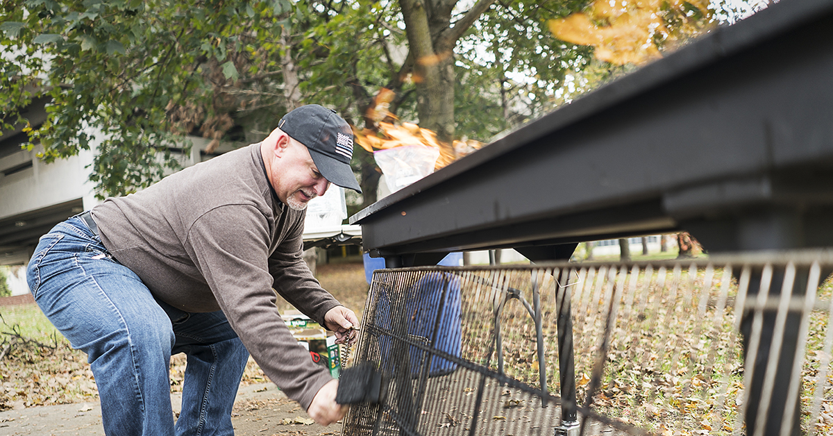 Steven Moore, 52, of Davison cleans the grate of the large grill at the Flint Community Cookout at the Riverbank Park. Moore, a retired police officer, enjoys being able to connect with the community in a positive way, which wasn't always the case wh