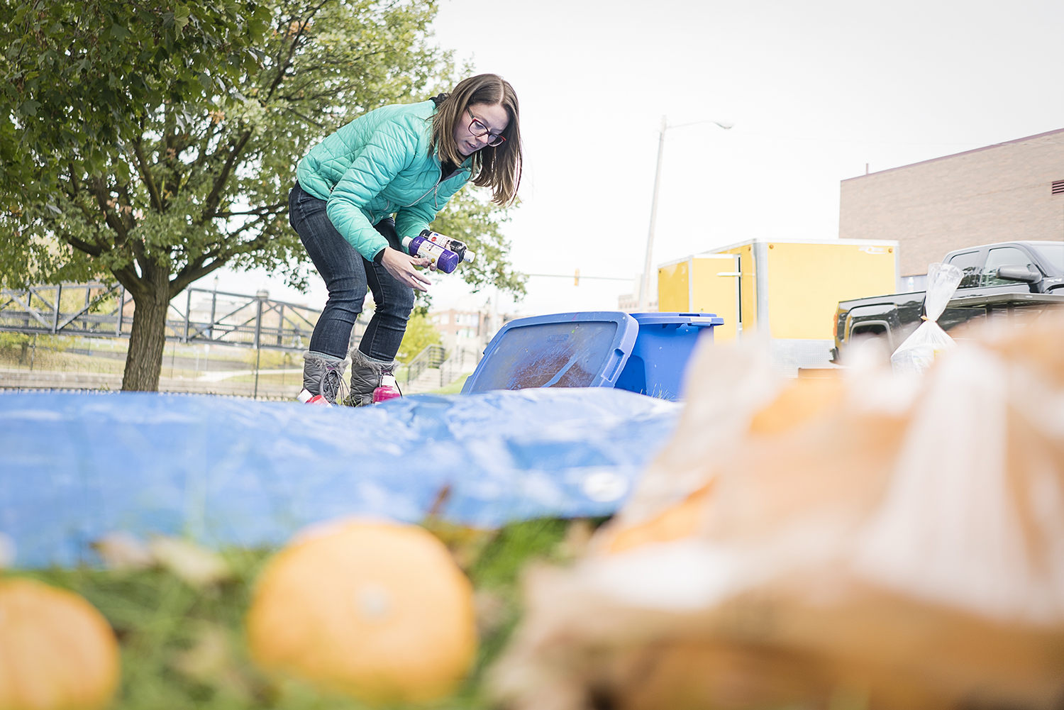 Co-organizer and Flint resident Sarah Elkins, 28, sets up a station for pumpkin painting at the Flint Community Cookout in the Riverbank Park. 