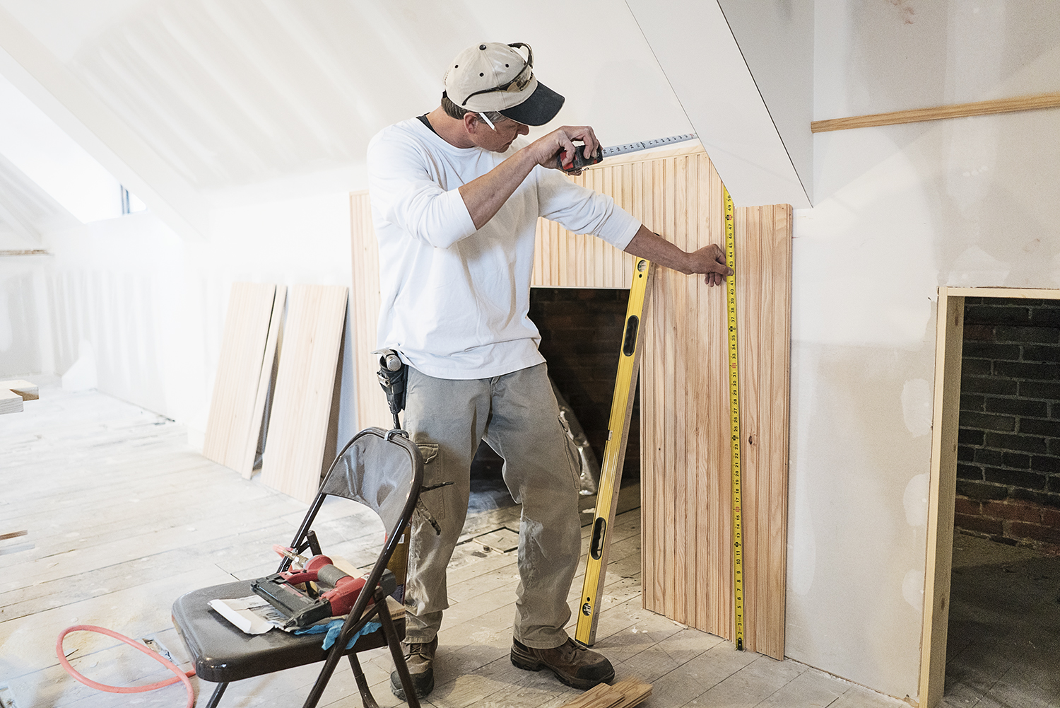 Flint, MI - Tuesday, October 31, 2017: Ensuring his measurements are accurate and perfectly level, carpenter Rob Smith, 43, of Oxford, works on installing bead board on the walls of the third floor in the Whaley Historic House Museum.
