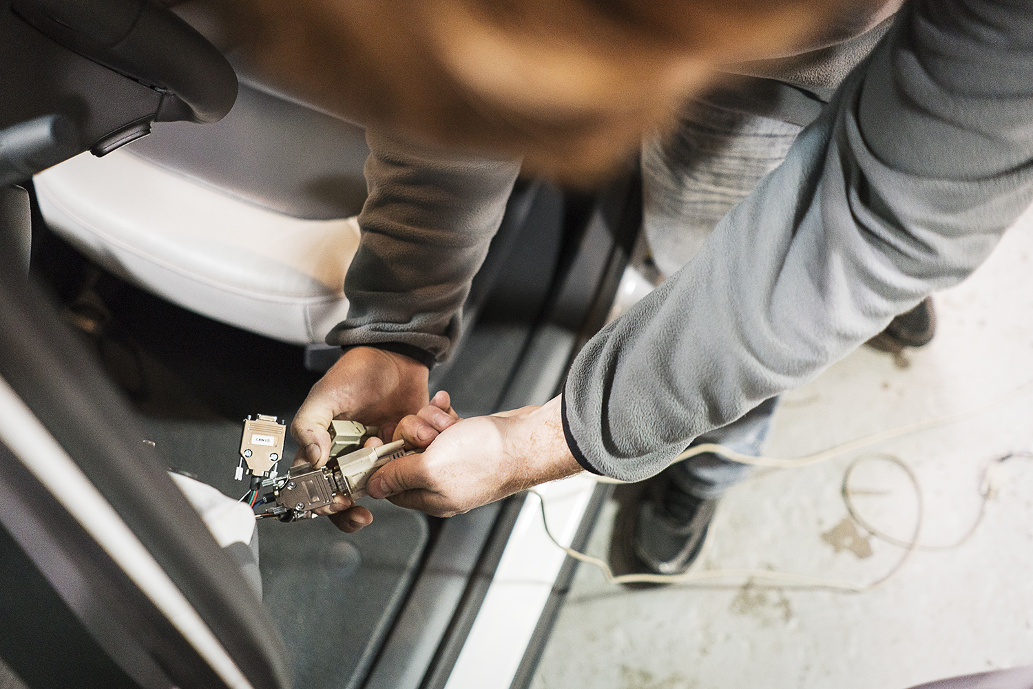 Flint, MI - Friday, November 10, 2017: Graduate student and student coordinator for the SAE/GM AutoDrive Competition, Alex Rath, 22, connects a server to the Chevrolet Bolt provided to them for the competition in the garage at Kettering University. 