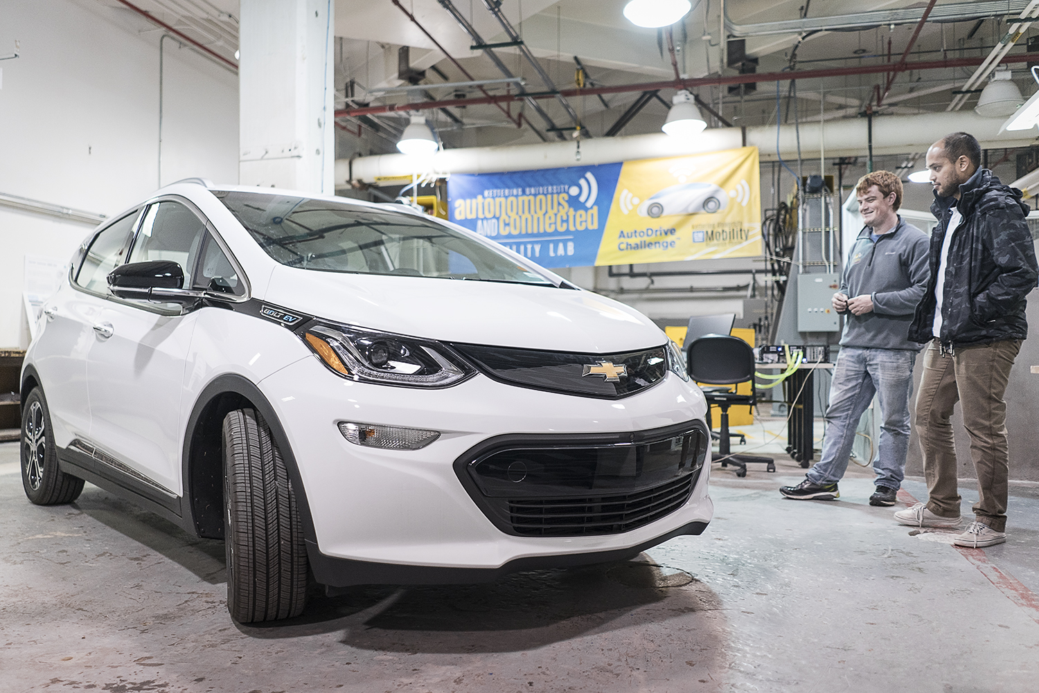 Flint, MI - Friday, November 10, 2017: Student coordinators for the SAE/GM AutoDrive Competition Alex Rath, 22 (left) and Shobit Sharma, 26, survey the new Chevrolet Bolt provided to the university for the competition in the garage at Kettering Unive