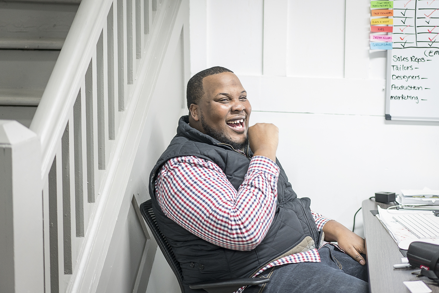 GoodBoy Clothing owner and creator Oaklin Mixon, 34, of Flint, has a laugh at his desk while his team readies the store and the products for the grand opening event on Friday, November 17, 2017 in downtown Flint.