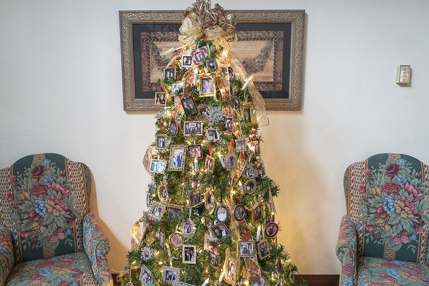 A Christmas tree adorned with portraits and ribbon stands in the foyer of the Heddy residence.