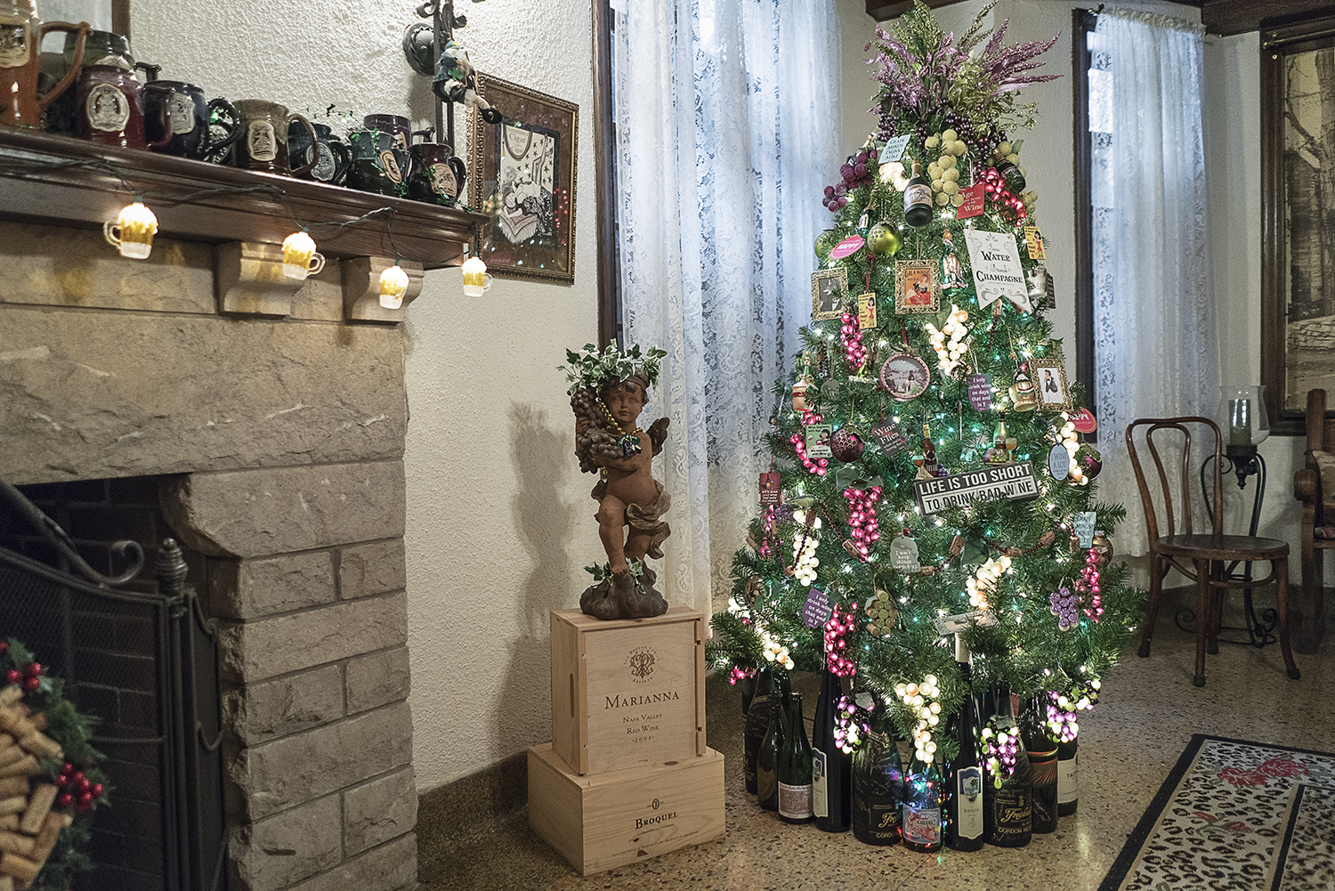 Illuminated bunches of grapes hang from a wine-themed Christmas tree in the basement pub in the Heddy home.