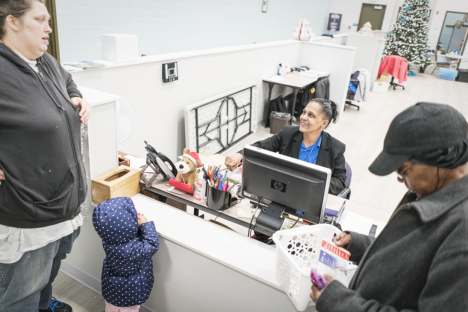 Redonna Riggs, 47, of Flint (center) assists clients at the Catholic Charities Community Closet at the Center for Hope. Riggs, the Community Closet Coordinator, has seen all aspects of the Catholic Charities program, having been a client at one point