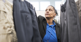 Community Closet Coordinator at the Catholic Charities Center for Hope Redonna Riggs, 47, of Flint, organizes donated clothing hanging from a clothing rack.