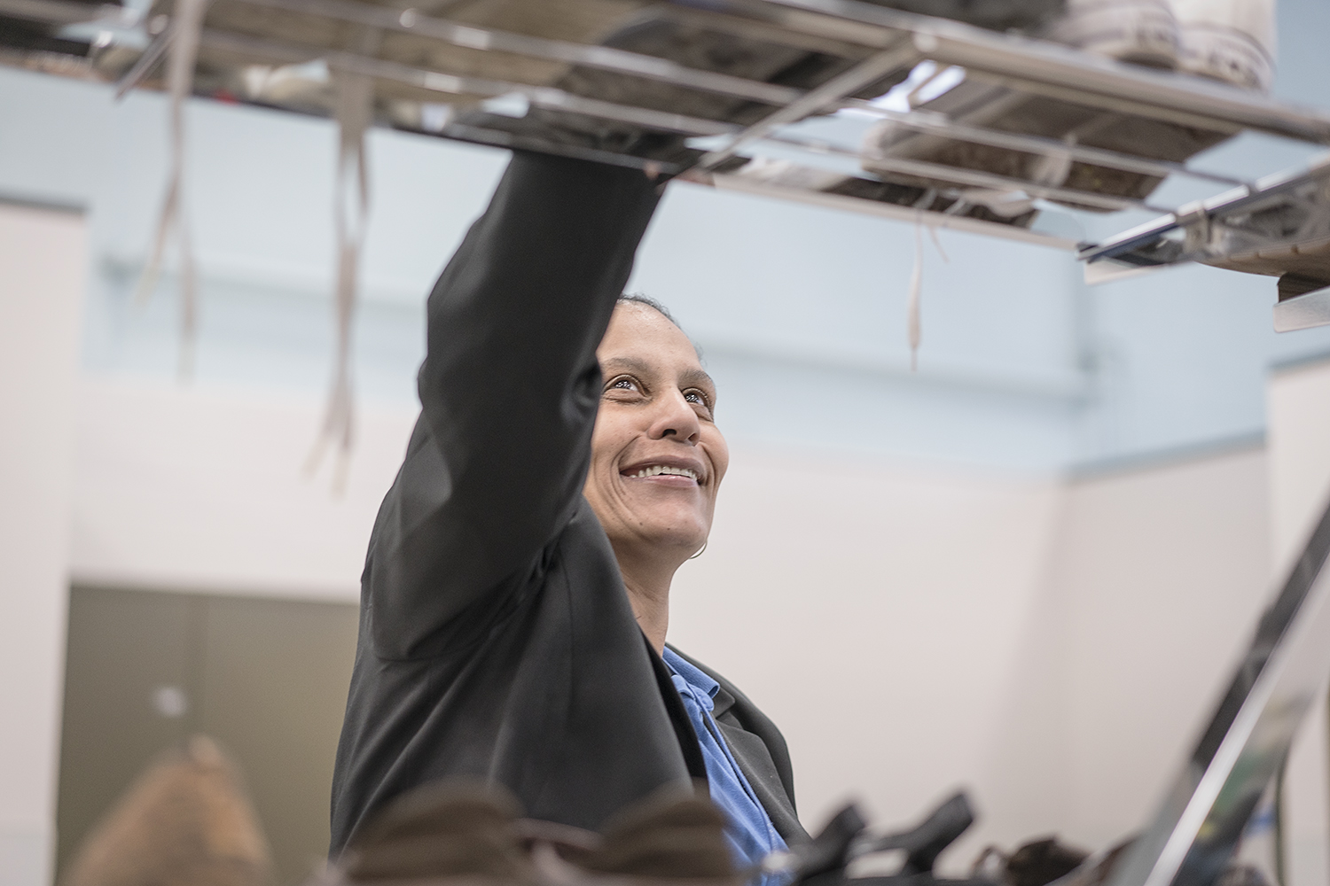 Smiling as she works, Redonna Riggs, 47, of Flint, the Community Closet Coordinator at Catholic Charities Center for Hope assists clients from all backgrounds get necessities such as clothing and personal hygiene products.