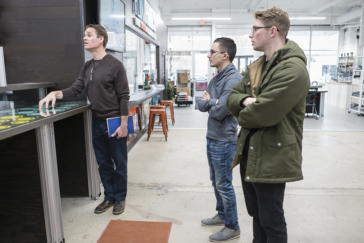 David Ollila, (left) president and chief innovation officer for Skypoint Ventures meets with the staff of 100K Ideas to get the day started.