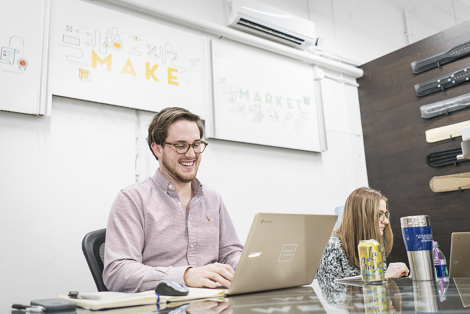 Gabriel Stone, 22, of Lapeer, (left) works on a project binder for a client at 100k Ideas. As a project manager, Stone assists inventors and innovators through the process of making their ideas a reality. 