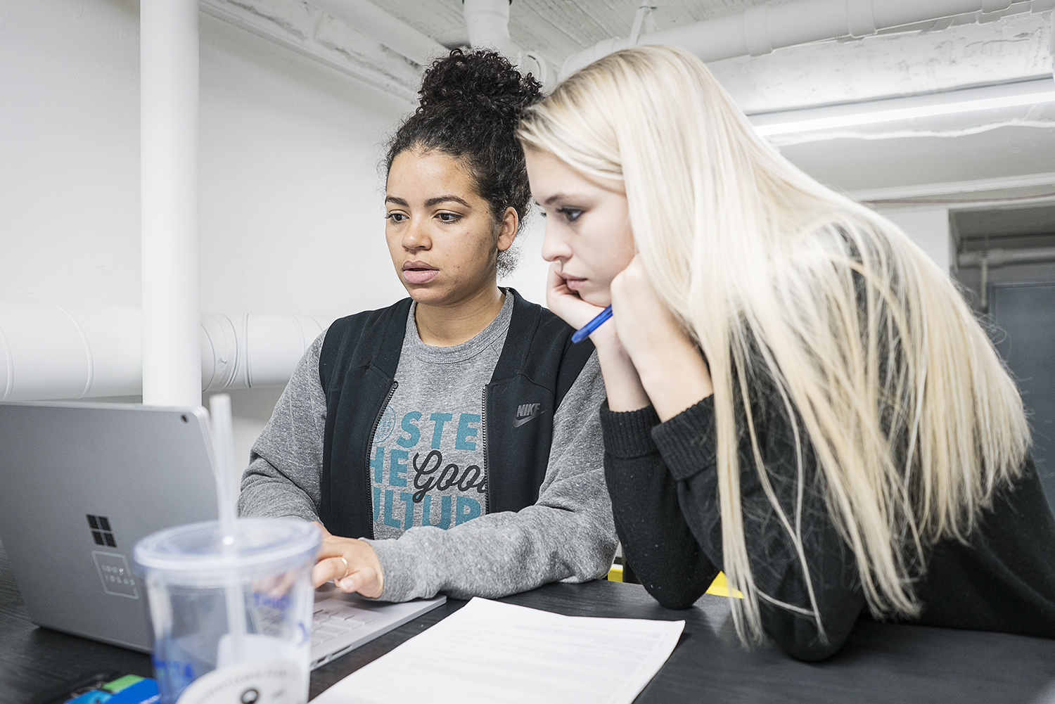 Jessica Judson, 32, of Flint, (left) a program manager for 100K Ideas, meets with Marketing Specialist Ariees Spangler.