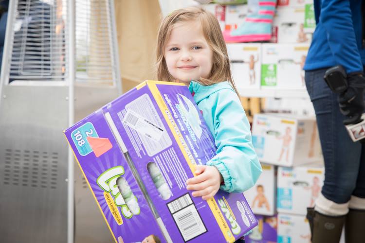 The Food Bank of Eastern Michigan helps distribute the 1.2 million diapers to needy families. Shown here: A girl makes a donation during the annual Diaper Drive in May 2017.