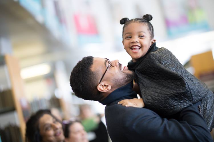 Isaiah Oliver picks up daughter Carrington, 4, after his MLK Day speech at Flint Public Library. 